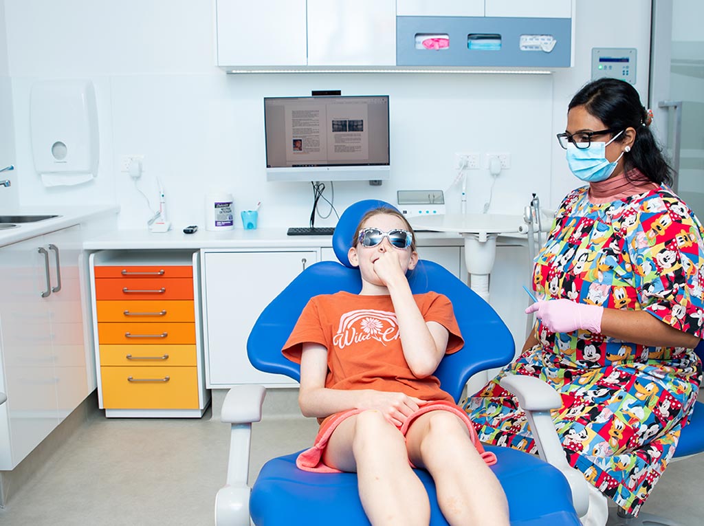Young patient wearing protective glasses during a dental check-up with an NLPD specialist dentist