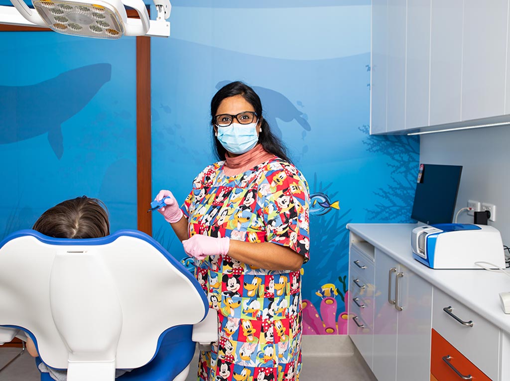 NLPD specialist dentist preparing to treat a young patient in the treatment chair