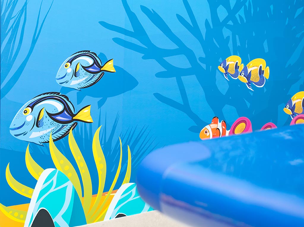 Colourful underwater-themed wall mural in an NLPD paediatric treatment room